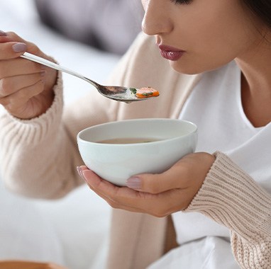 A woman having a bowl of soup