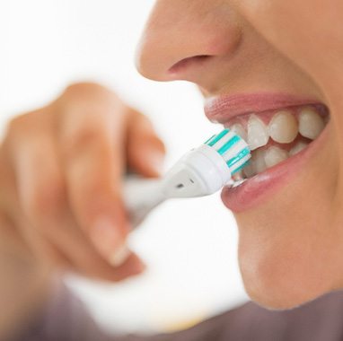 A closeup of a young woman brushing her teeth
