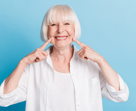 Woman smiling with dentures on blue background