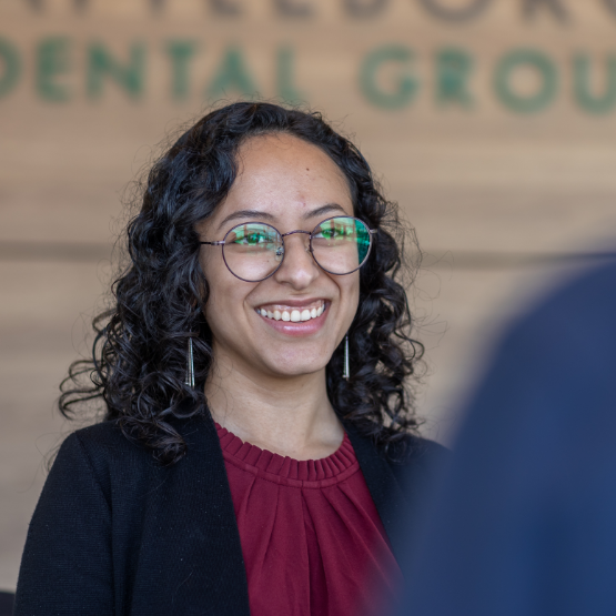 Dental team member at front desk smiling at a patient