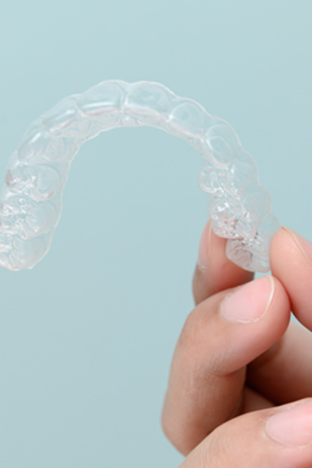 Closeup of patient holding clear aligner