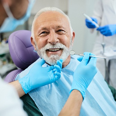 An older man receiving dental care from his dentist