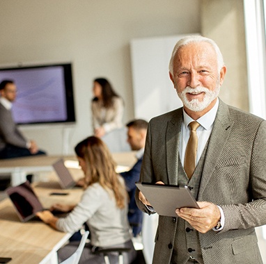 A smiling, mature businessman working in an office setting