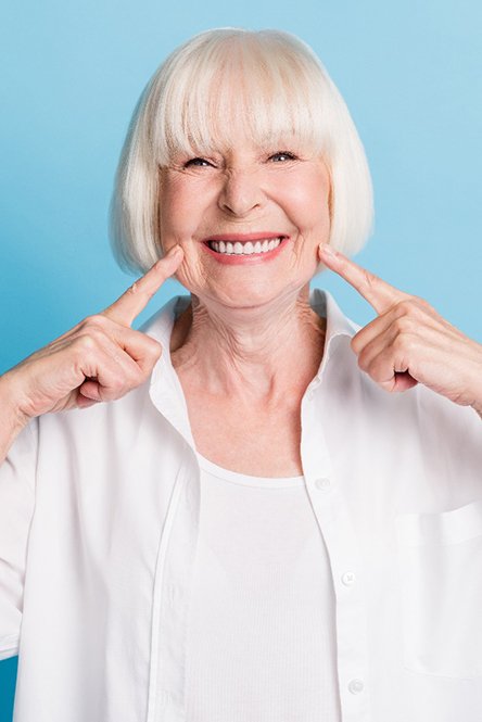 Woman pointing to her smile