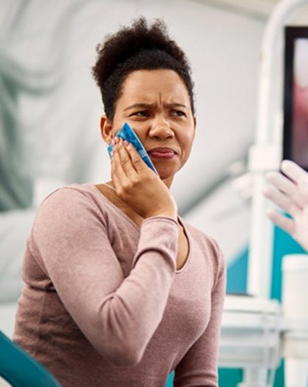 a woman visiting her dentist due to a dental emergency