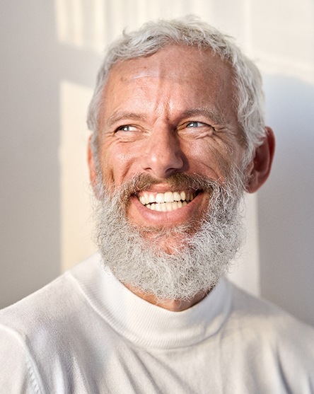 Bearded man in a white shirt smiling