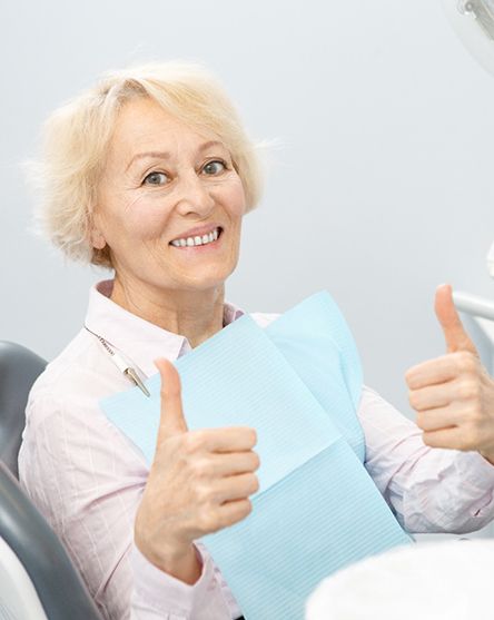 Senior woman at dentist’s office giving two thumbs up