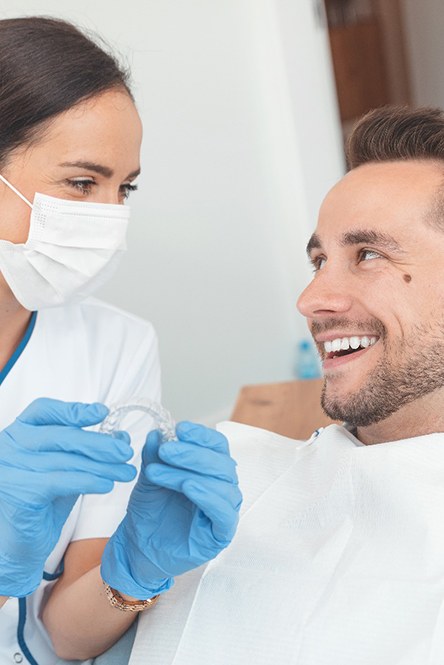 Dentist showing her patient an Invisalign aligner