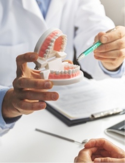 Dentist explaining dental treatment using smile model