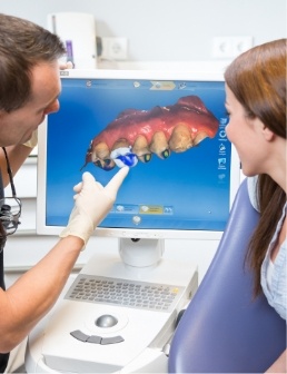 Dentist and dental patient looking at digital impressions of teeth and gums