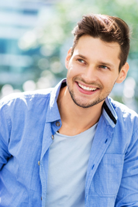 Man in blue button-up shirt smiling