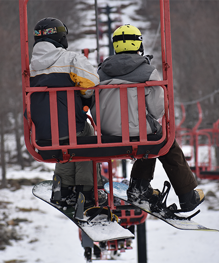 2 snowboarders on a cart