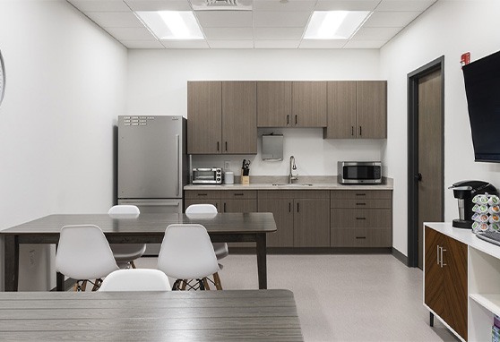 Break room with tables a microwave and a refrigerator