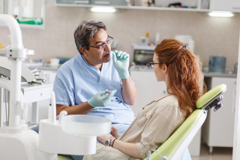 A dentist explaining dental crown lifespan to his patient