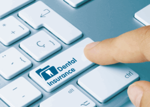 a person pressing a button that reads “dental insurance"